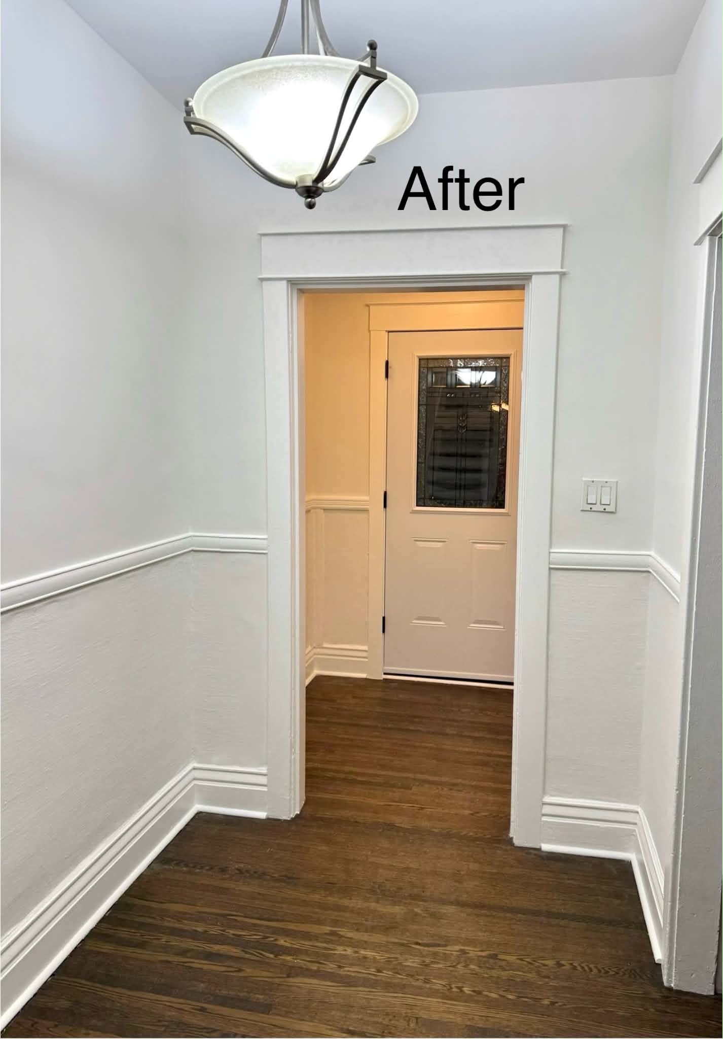 The same entryway after renovation, with plaster repaired and trim and walls freshly repainted